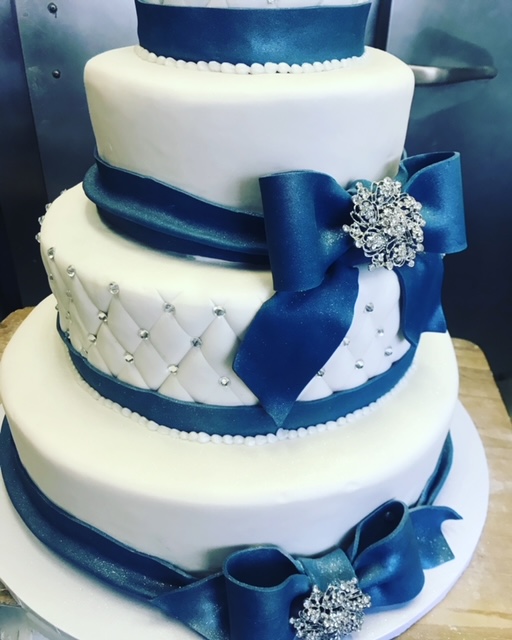 Layered white cake decorated with blue bows